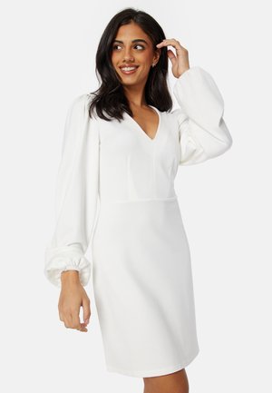 Robe blanche longueur genoux avec un décolleté en V, un corsage structuré et des manches volumineuses avec des poignets froncés. Fabriquée en tissu doux.