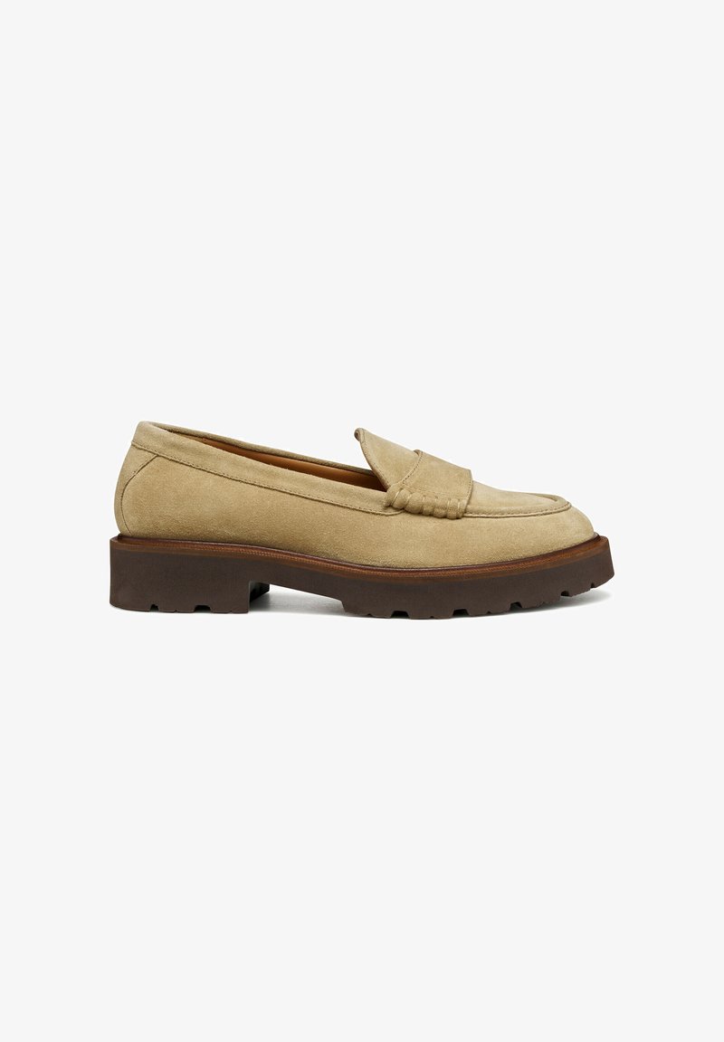 Mocasines de ante beige con suela de goma estriada, que presentan un diseño de mocasín cosido y una pequeña solapa decorativa en el empeine.