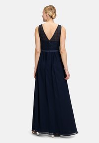 Granatowa sukienka z koronkowym gorsetem, głębokim dekoltem V na plecach oraz zwiewną spódnicą sięgającą do podłogi. Wykończona wstążką w talii.