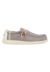 Scarpa slip-on grigia in tela con suola in gomma crema, caratterizzata da un'accortezza cucita e dettagli di laccio marrone. Design leggero con costruzione minimal.