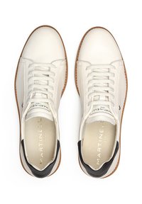 Zapatillas blancas de cuero con un acabado texturizado, que cuentan con una puntera redondeada, cierre de cordones y un acento en el talón negro. Suela de goma marrón.