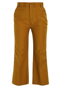 Pantalons larges en jaune moutarde, avec une texture lisse, une fermeture à bouton à l'avant et deux poches latérales. Coupe ajustée avec un devant plat.