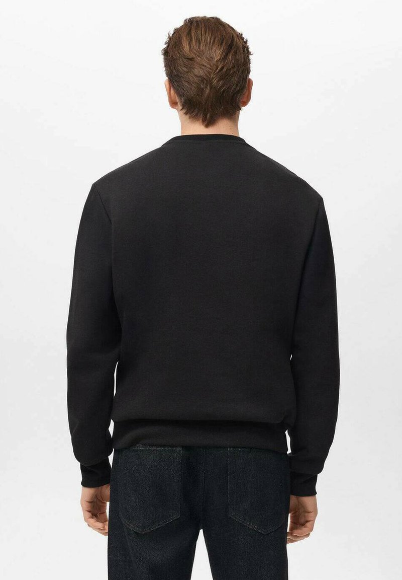 Sudadera negra de algodón con cuello redondo y un corte relajado, puños y dobladillo acanalados, que presenta una textura suave y sin logotipos ni patrones visibles.