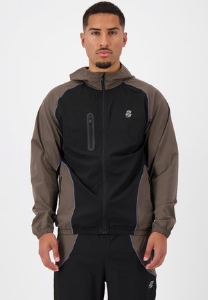 Zwarte en bruine windbreakerjas met blauwe accenten, voorzien van een volledige rits, capuchon en een ritszak op de borst. Lichtgewicht, gladde textuur.
