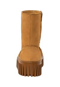 Tan suède enkelboots met een ronde neus, verticale naaddetail en een geribbelde rubberen zool. Achterrits voor gemakkelijke toegang.