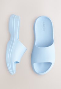 Sandales à glissière bleu clair avec une texture lisse, design à bout ouvert et accent découpé. Fabriquées en matériau flexible. Convient pour un usage décontracté.