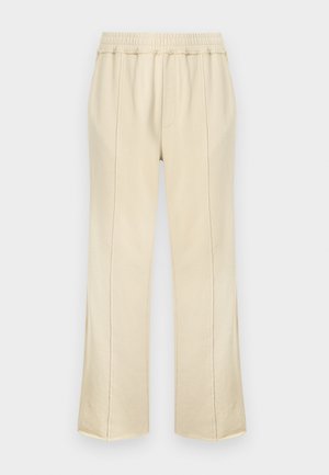 Pantalones casuales de color crema con cintura elástica y costuras verticales visibles, corte recto en la pierna, sin detalles visibles de cierre.