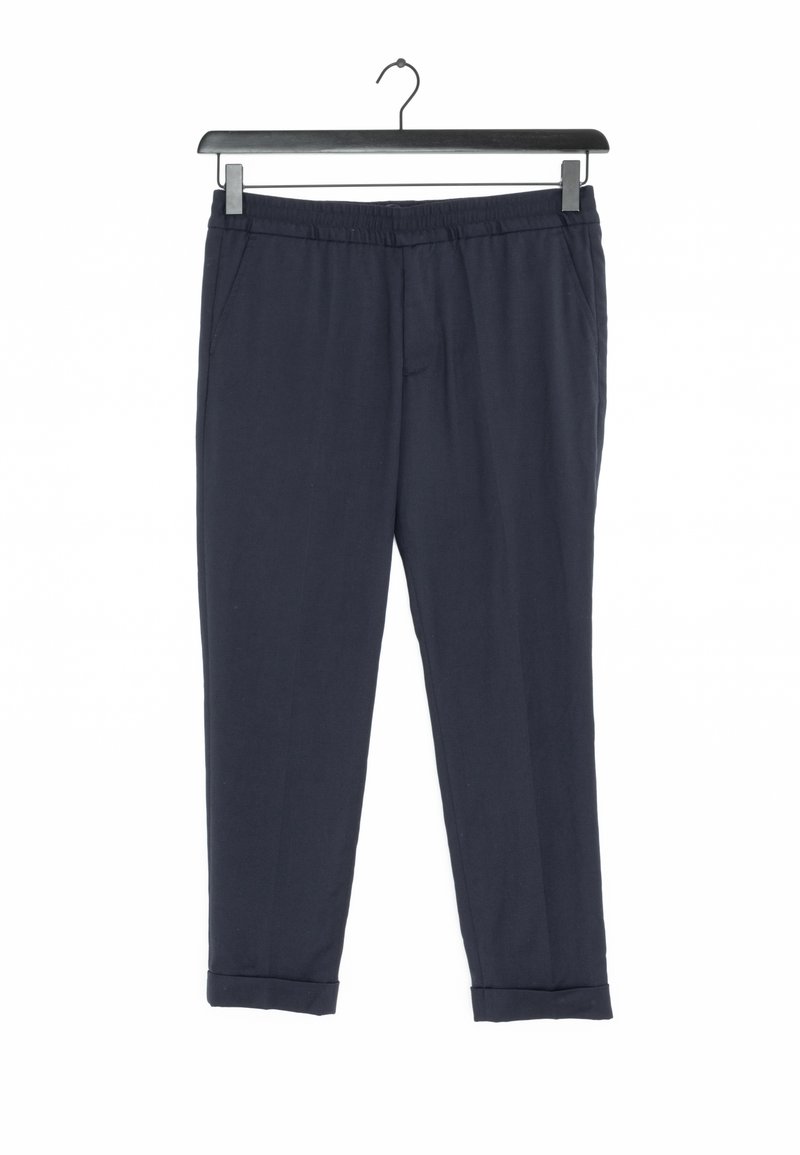 Pantalon bleu marine taillé, taille élastique et ourlets retroussés, suspendu sur un cintre noir contre un fond blanc.