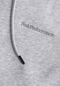 Grauer Sweatshirt mit einem charakteristischen gestickten "PeakPerformance"-Logo. Enthält eine strukturierte Kordel mit schwarzem Ende.