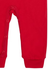 Roter Baumwoll-Overall mit langen Ärmeln, mit Druckknopfverschlüssen am Boden und elastischen Bündchen, glatte Textur und ohne sichtbare Muster.