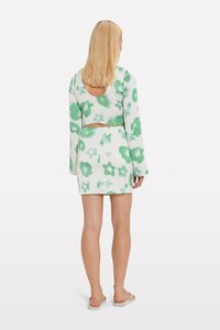 Ensemble à deux pièces à motif floral vert, avec des manches longues, un top court et une jupe taille haute. La texture est côtelée ; détail découpé au dos.