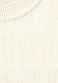 Pull tricoté de couleur crème avec un col rond côtelé et de subtils motifs en câbles verticaux.