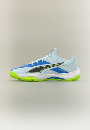 Scarpa sportiva azzurro chiaro con logo nero, dettagli blu e suola verde neon, vista di lato su sfondo neutro.