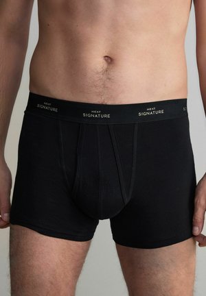 Schwarze Boxershorts aus weichem Stoff mit enger Passform. Mit einem elastischen Bund in Schwarz mit goldenen Buchstaben.