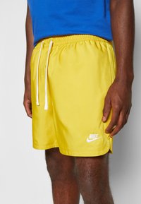 Nike Sportswear M NSW SPE WVN LND FLOW SHORT - Calças de fato de treino - vivid sulfur/white