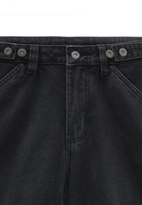 Pantalon en denim noir à taille haute, doté de deux boutons métalliques, d'une fermeture éclair et de poches avant inclinées. Tissu texturé avec un léger éclat.