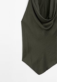Mörk olivgrön ärmlös topp med draperad halsringning och spetsig nederkant mot en vit bakgrund.