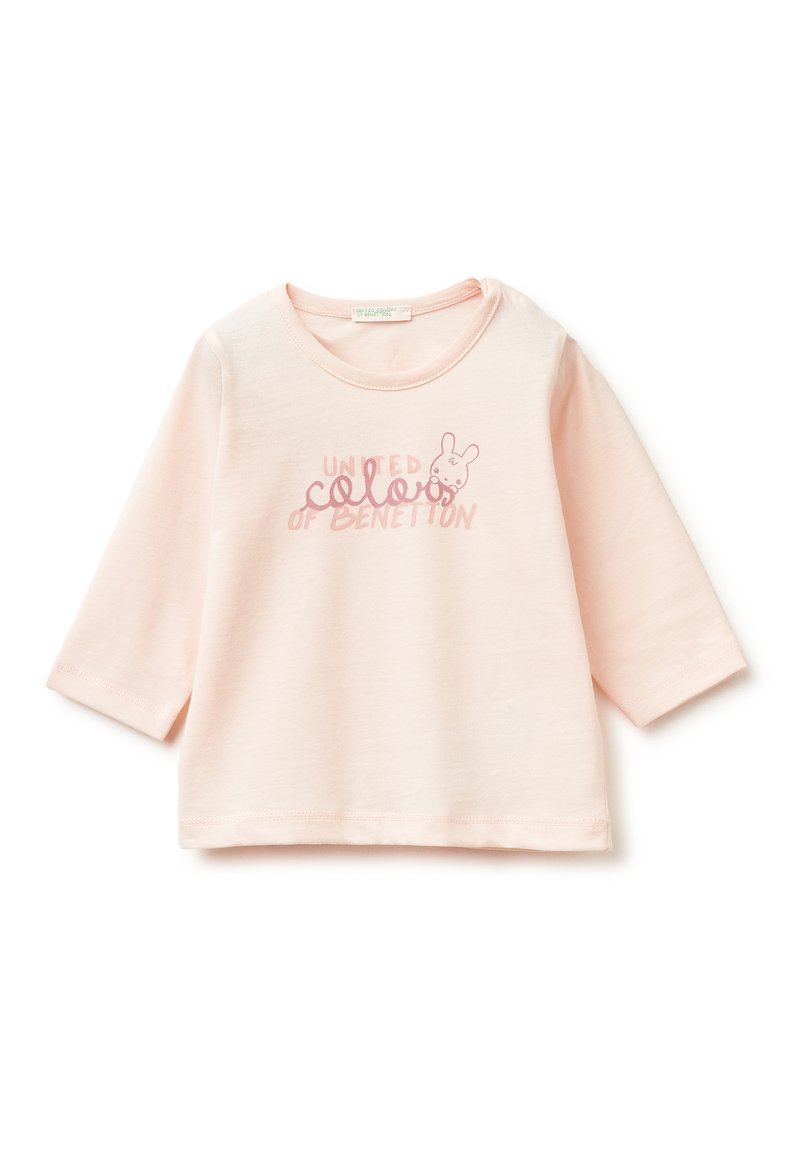 Světle růžové bavlněné tričko se třemi čtvrtinovými rukávy. Obsahuje text "United Colors of Benetton" a malou grafiku králíčka v jemných barvách.