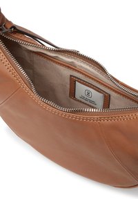 Brun läderhandväska med en mjuk textur, dragkedjestängning och ett mönstrat tygfoder. Har en etikett för "The Swedish Leather Brand."