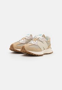 Beżowe buty sportowe z siateczkowym i zamszowym materiałem, z jasną podeszwą i jasnoniebieskimi akcentami na języku. Teksturowana podeszwa.