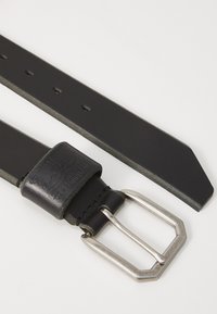 Cintura in pelle nera con una finitura leggermente testurizzata, dotata di una fibbia ottagonale in argento e di una fascia in pelle marcata con fori per la regolazione.