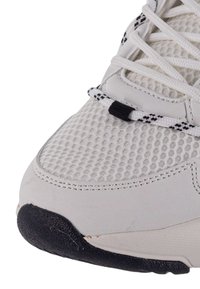 Scarpa sportiva bianca con una tomaia in rete, superficie testurizzata, suola in gomma nera e una lacerazione distintiva con un accento nero.