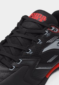 Μαύρο αθλητικό παπούτσι με μαύρα κορδόνια, κόκκινη και λευκή σήμανση, λεπτομέρειες "Perfect Fit" και "Ventilation System" στην πλευρική επιφάνεια.