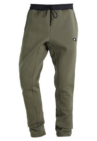 Olivgrüne Jogginghose aus weichem Material, mit einem schwarzen elastischen Bund und Kordelzug, Seitennähten und einem kleinen Logo-Patch.