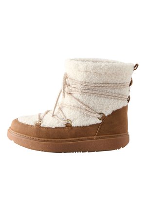 Beżowe botki za kostkę z puszystą białą cholewką, ozdobione koronkami i złotymi elementami. Podeszwa z teksturą zapewnia przyczepność i stabilność.