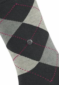 Schwarzer und grauer Socke mit Rautenmuster und pinken Nähten. Verfügt über einen runden Metallakzent nahe dem unteren Ende. Hergestellt aus einem glatten, gestrickten Material.