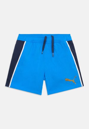 Erksinised ujumispüksid mustade külgpaneelide, valgete triipude, elastse vöökohaga, mustade nööridega ja vasakul jalal kuldse Puma logoga.