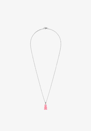 Collar de cadena plateada con un pequeño colgante rosa en forma de osito de gominola colgando en el centro sobre un fondo blanco.