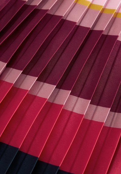 Tessuto plissettato in tonalità di rosso, rosa e arancione con una texture liscia. Presenta strisce orizzontali di larghezze e colori variabili.