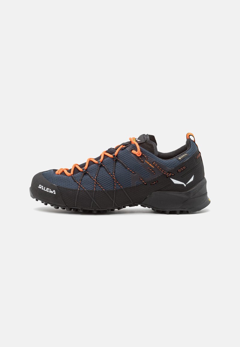 Scarpa da trekking blu scuro con lacci arancioni, parte superiore in rete e suola in gomma nera. Presenta una punta rinforzata e impugnature testurizzate per una migliore aderenza.