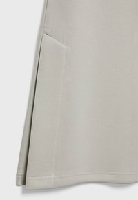 Svetle šedá sukně vyrobená z hladkého, elastického materiálu. Má boční kapsu a lem s pečlivým stehem. Minimalistický design.