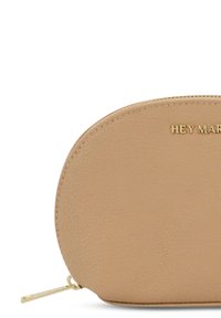 Beige leren pouch met een ronde vorm, voorzien van een gouden ritssluiting en subtiele korrelstructuur. "HEY MAR" in het goud gepreegd aan de voorkant.