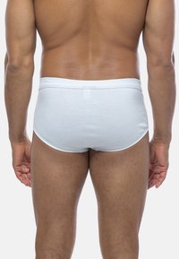 Weiße Baumwollunterw�äsche mit einem weichen Bund, der eine glatte Textur und eine abgerundete Form aufweist. Sichtbare Nähte entlang des Bundes und der Beinöffnungen.