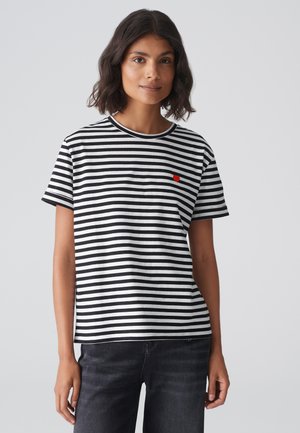 T-shirt a righe bianche e nere in cotone, con maniche corte, scollo rotondo e un piccolo logo a forma di cuore rosso sul petto.