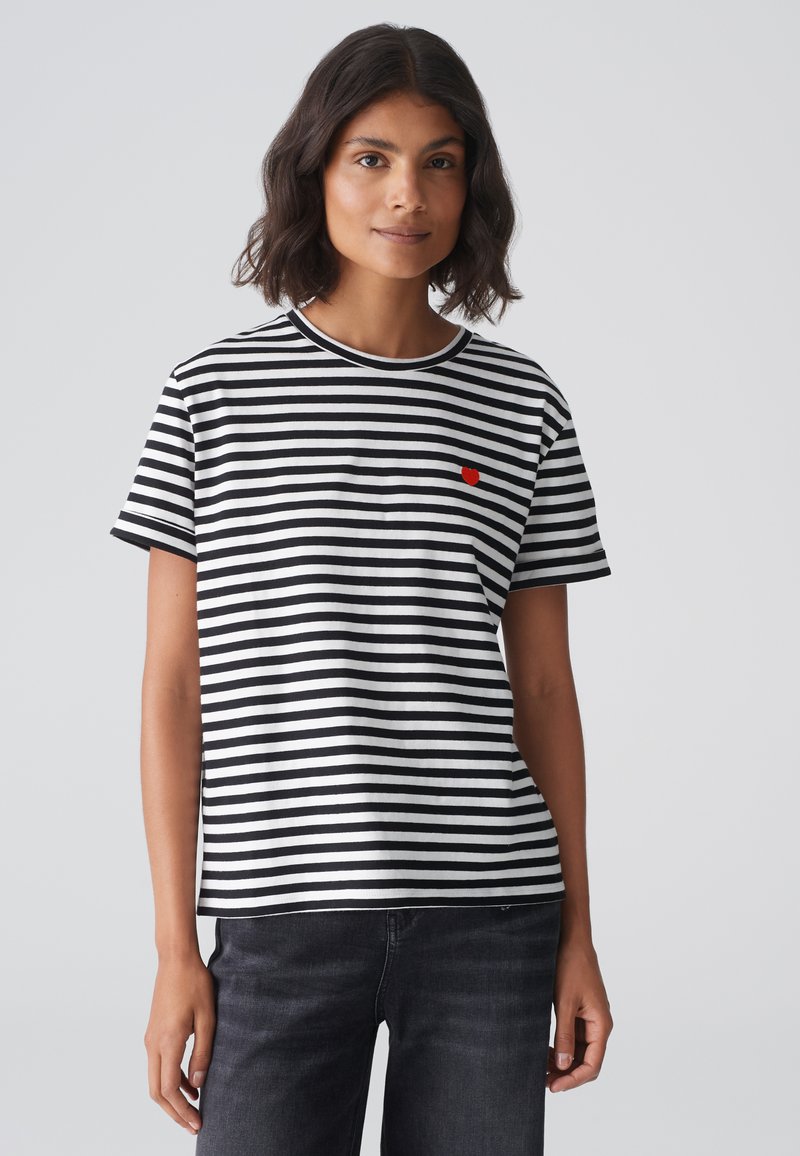 Black and white striped t-shirt made of cotton, featuring short sleeves, a round neckline, and a small red heart logo on the chest.