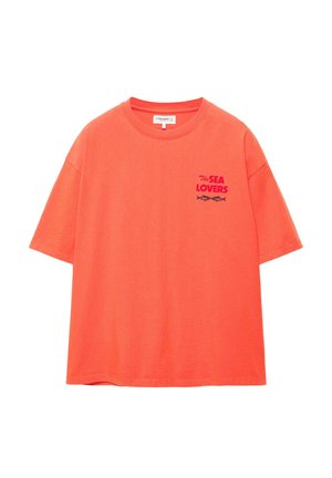 Svetlo oranžové tričko s krátkym rukávom a nápisom "The Sea Lovers" spolu s grafikou dvoch rýb na ľavej strane hrudníka.