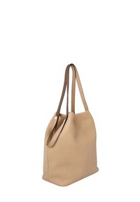 Bolso tote de cuero beige con asas para el hombro marrones. Presenta una superficie suave y texturizada y una parte superior redondeada. Diseño minimalista, forma sin estructura.