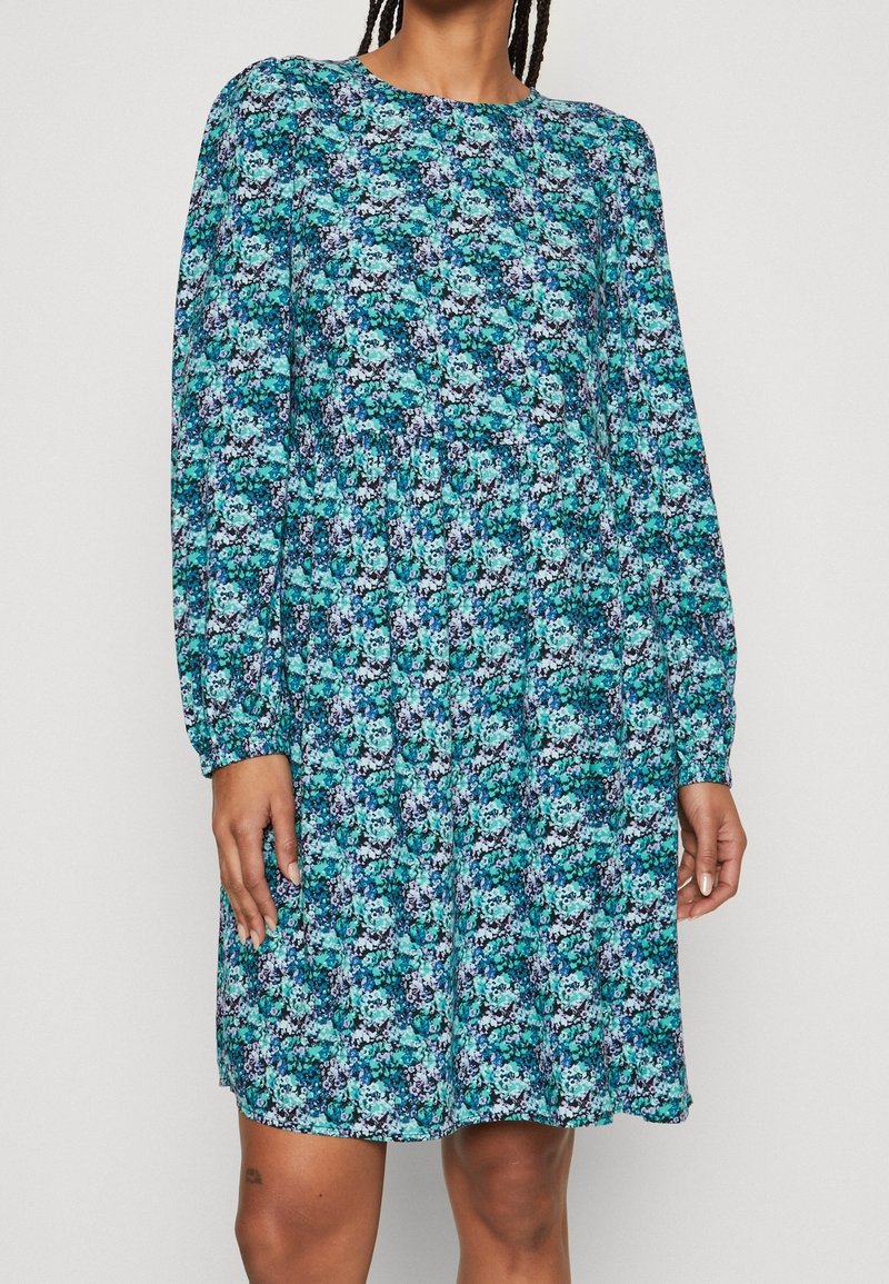 Blommig klänning med långa ärmar, rund halsringning, i blå och gröna nyanser, med en samlad midja och en svängig silhuett.