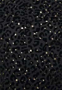 Černá látka s texturovaným vzorem leopardího tisku v různých zlatých a černých odstínech, s rozptýlenými metalickými akcenty.