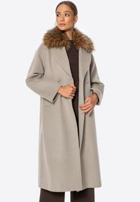 Hellgrauer Wollmantel mit einem Doppelreißverschluss-Design und großem, pelzigem Kragen. Verfügt über weite Ärmel und Seitentaschen.