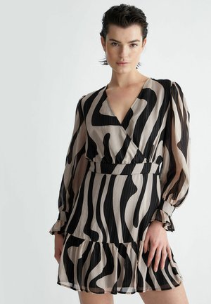 Abito nero e beige caratterizzato da un motivo a strisce zebra, scollatura a V, maniche lunghe a sbuffo e orlo arricciato realizzato in tessuto leggero.