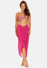 Kolorowy biustonosz bikini z geometrycznymi wzorami oraz różowa, przezroczysta sarong z węzłem i detalem w postaci srebrnego pierścienia, ukazujący zwiewną teksturę.