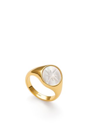 Gouden zegelring met een ronde witte inzet waarin een achtpuntige ster is gesneden, schuin op een witte achtergrond.