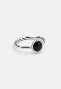 Anello in argento con una pietra nera centrale circondata da un anello di zirconia cubica trasparente, con una banda liscia e lucida.