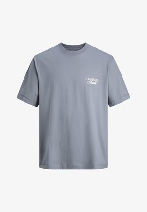 Jasnoniebieski bawełniany t-shirt z krótkim rękawem, okrągłym dekoltem i białym napisem "ORIGINALS Studio" na lewej piersi.