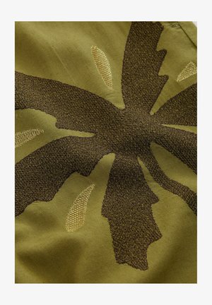 Textil mit einem olivgrünen Hintergrund und einem dunkelbraunen Blattdesign. Das Blatt hat eine strukturierte Oberfläche und goldene Akzente.